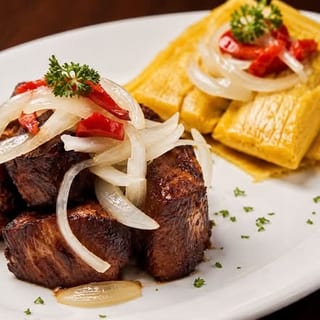 MASAS DE CERDO FRITA CON DOS TAMALES EN HOJA