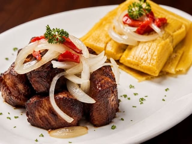 MASAS DE CERDO FRITAS CON DOS TAMALES EN HOJA.